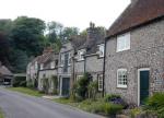 A street in Eastdean with the pretty flint cottage near the village green.